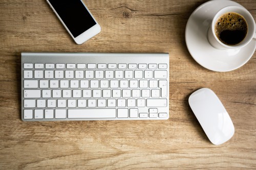 Клавіатура, кава, мишка і смартфон лежать на столі