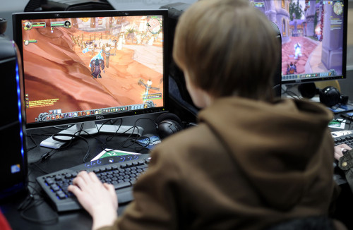 Молода людина грає в гру на комп'ютері